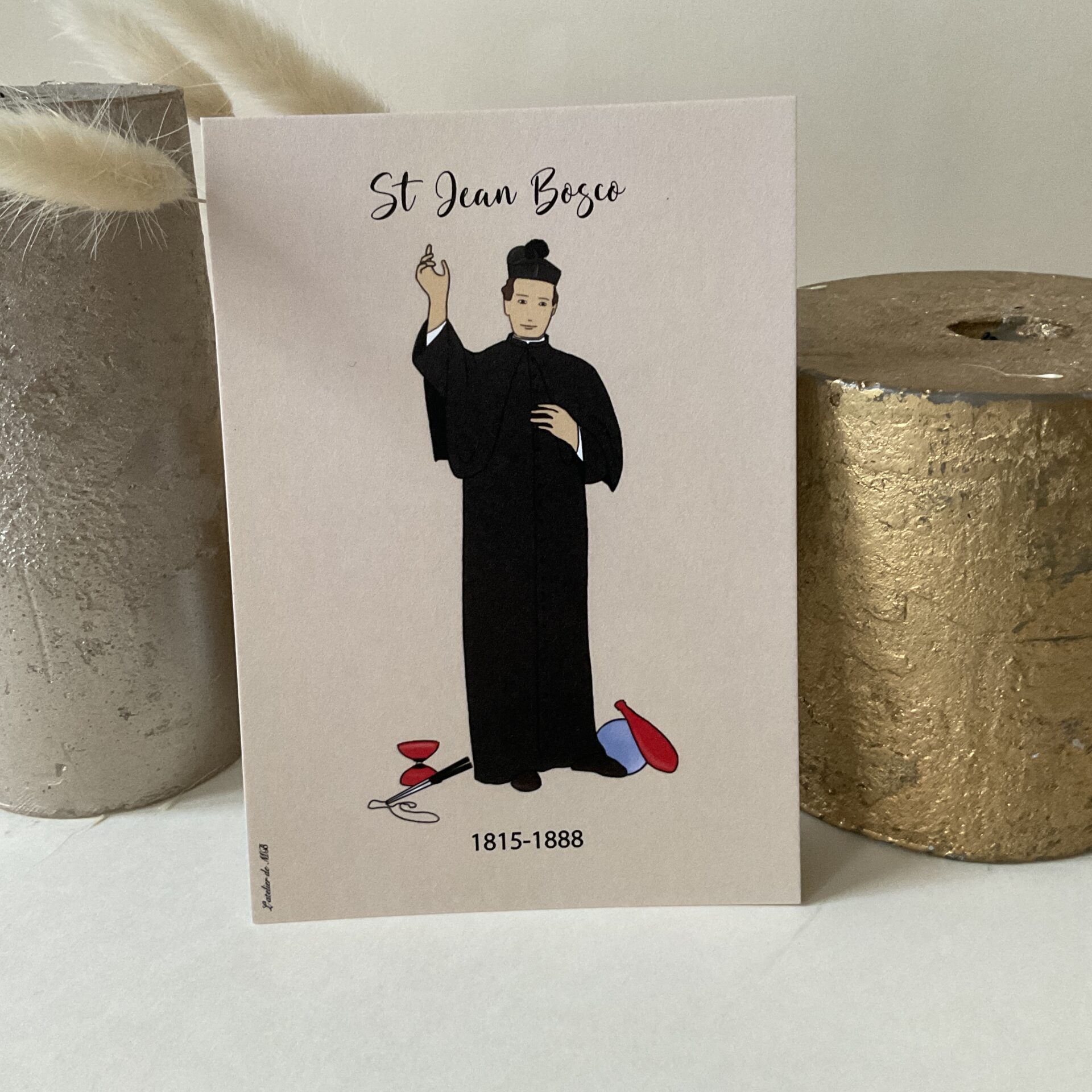 Carte de Saint Jean Bosco, représenté avec des jeux, lui qui aimait tant jouer avec les jeunes! Imprimée au format A6 sur du papier 300g. Pour fêter ceux qui portent le prénom Jean mais aussi Bosco!